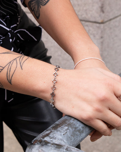 woman wearing nolo jewelry celtic cross bracelet and 1mm dainty tennis gemstone bracelet