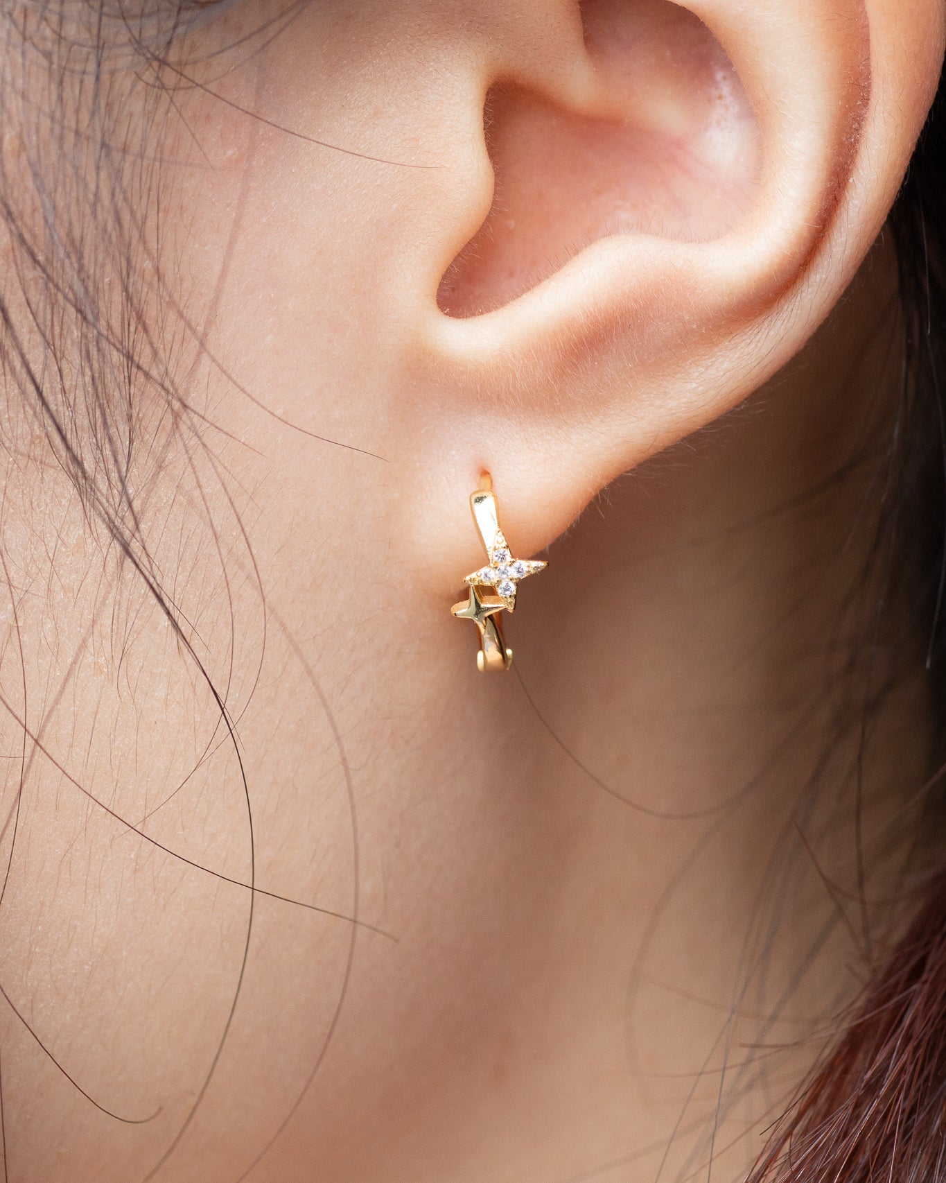 woman wearing Twinkle Dainty Star Cross Huggie Earrings, Cute Tiny Star Cross Earrings, Small Star Earrings, Gold Plated Sterling Silver Double Earrings