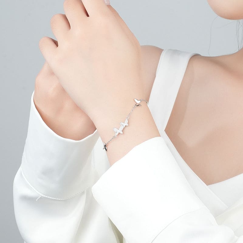 woman wearing nolo multi flying butterflies dainty chain link silver bracelet