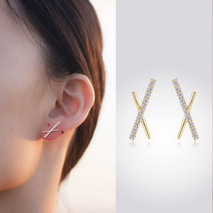 woman wearing nolo xquisite asymmetrical irregular x shaped cubic zirconia gemstone gold plated sterling silver stud earrings