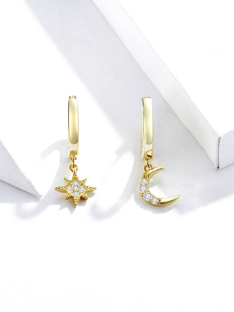 gold plated moon and star earrings set on table