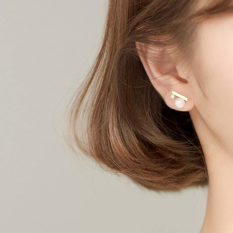 woman wearing modern contemporary pearl shell bar 18k gold plated 925 sterling silver cubic zirconia earrings