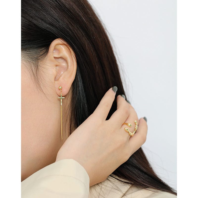 woman wearing nolo swing chain cross dangle gold earrings